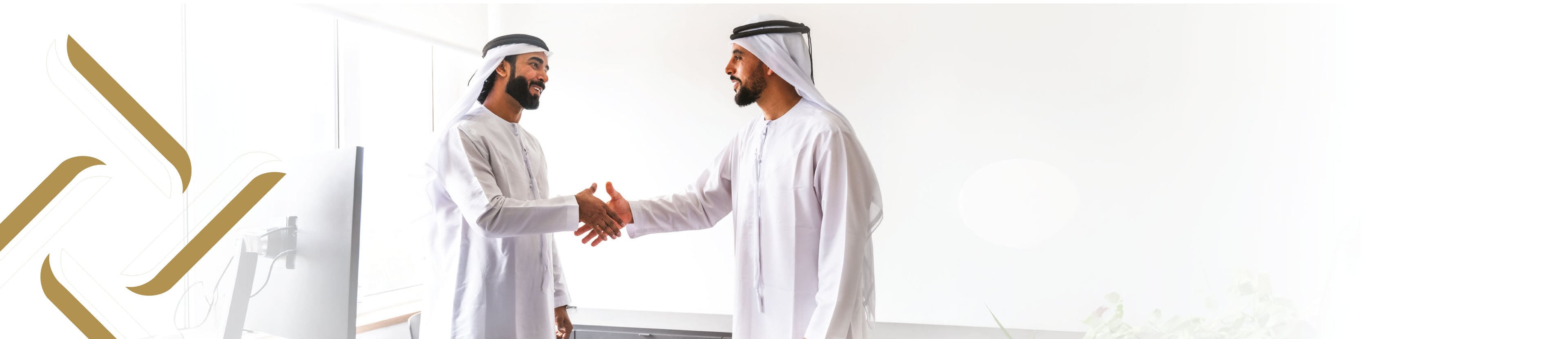 مصافحة بين شخصين بالزي الإماراتي ترمز إلى الشراكة والاستشارة القانونية في مركز إتمام